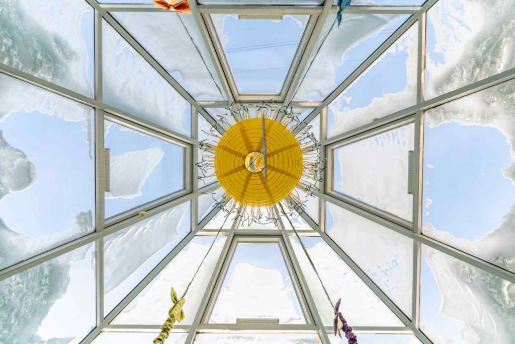 looking-up-at-snow-covered-glass-atrium-with-yellow-lantern